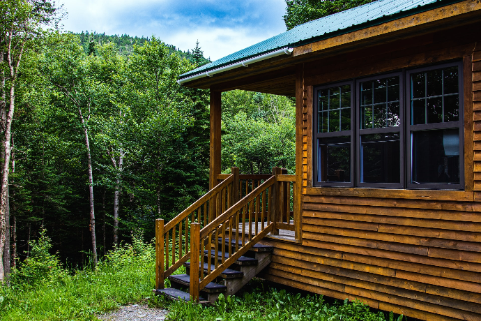 a wooden cabin in the woods with steps leading up to it